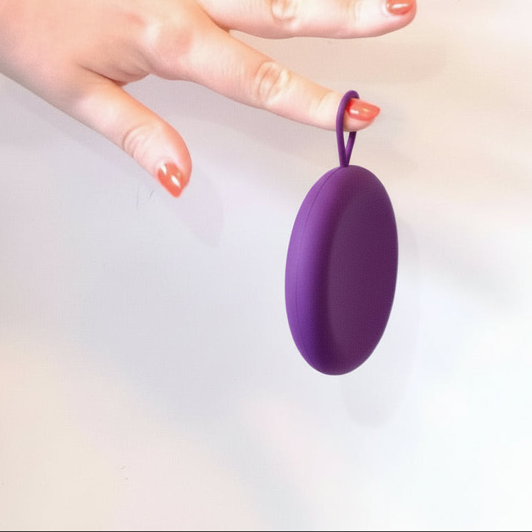 VelunaCase- hygiejnisk opbevaring til menstruationsdisk. En hånd løfter beholderen i dens ophængningsring.