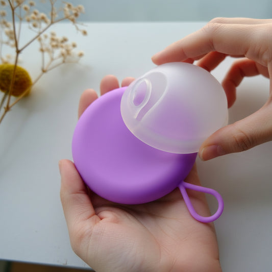 VelunaCase og VelunaDisc - menstruationsdisk med nem udtagningsring. ENn kvinder holder dem i hendes hånd. 