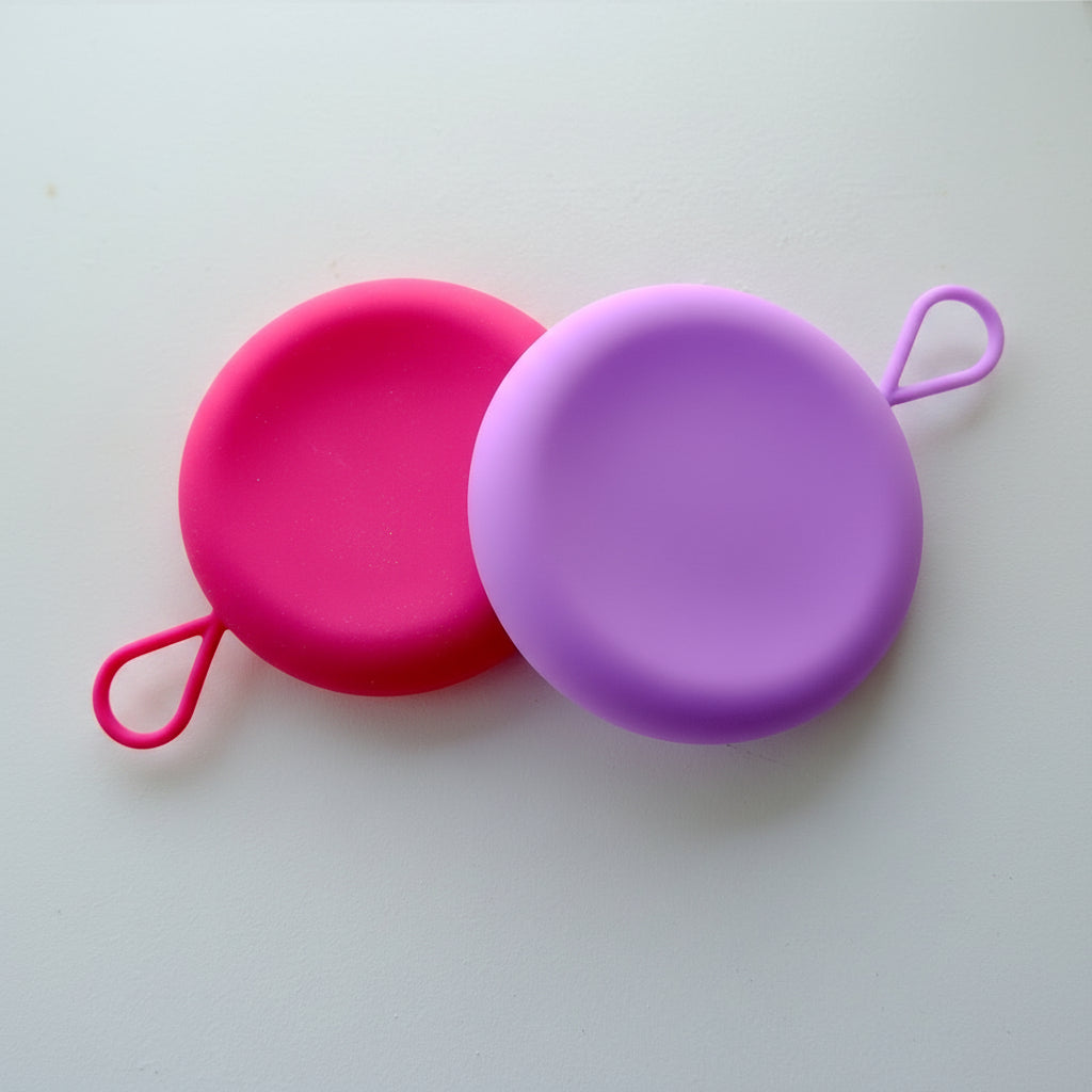 VelunaCase- hygiejnisk opbevaring til menstruationsdisk.  Der er to farver repræsenteret, pink og lilla. 